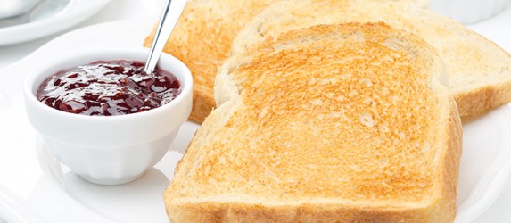 breakfast with toasts, jam, coffee and orange juice, horizontal closeup
